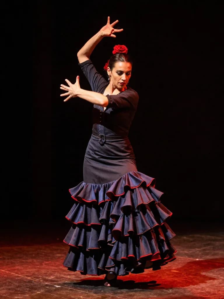 Portrait of a flamenco dancer mid-spin in dramatic stage lighting